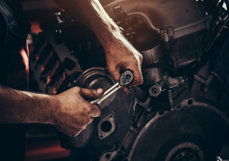 Man using tools to fix car