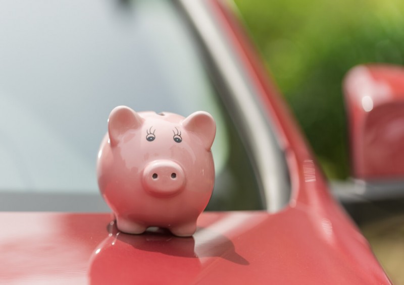 Piggy bank on red car bonnet