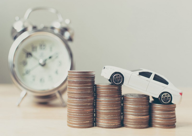 Stacked coins on table with toy car